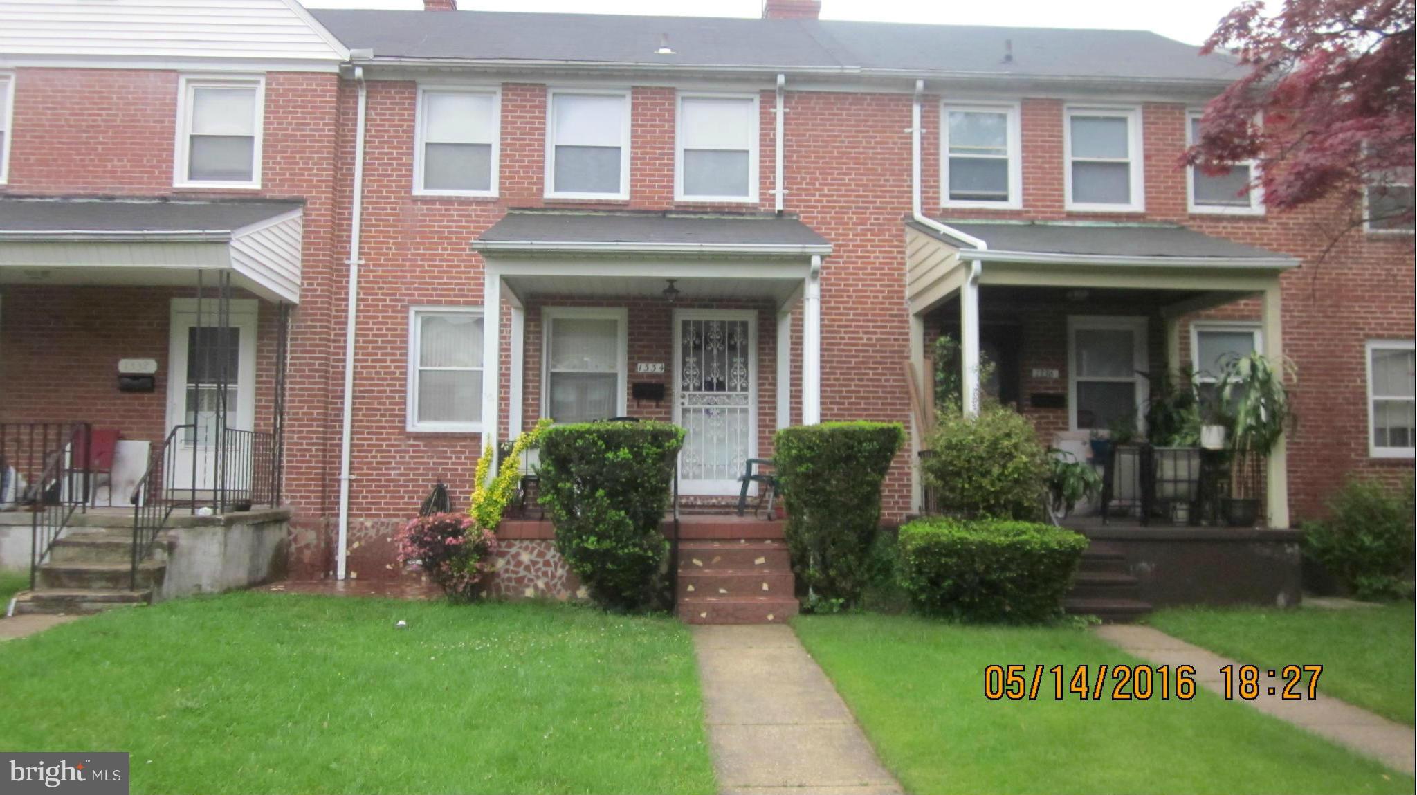 1334 Stonewood Road Baltimore, MD 21239 - Photo 1 of 18 a front view of a brick house with a yard