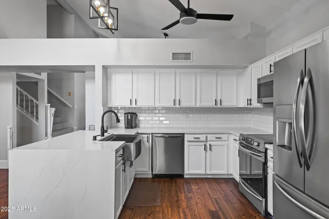 a kitchen with stainless steel appliances a refrigerator sink and microwave