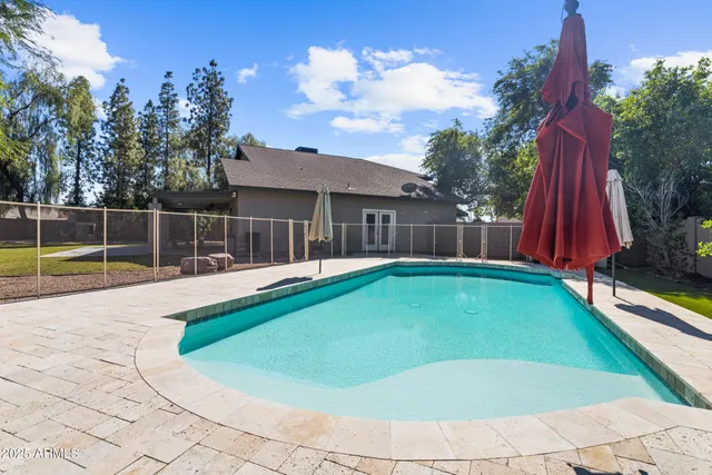 a view of a swimming pool with a slide and a yard