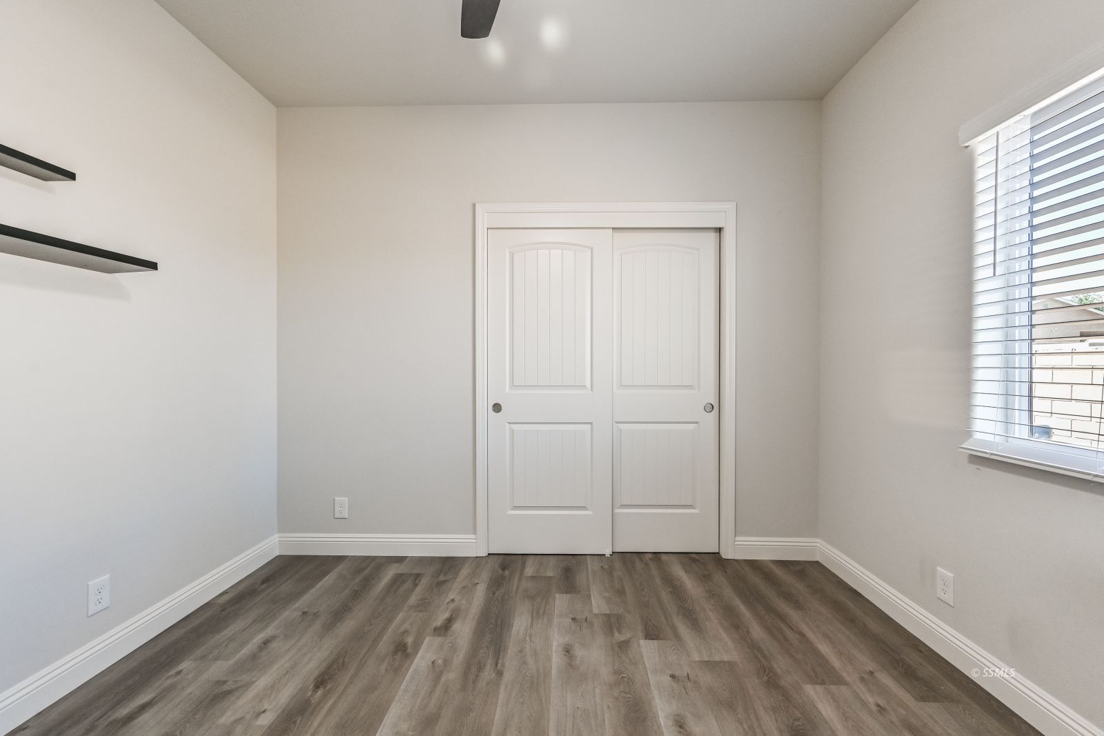 1031 West Church Avenue Ridgecrest, CA 93555 - Photo 36 of 49 a view of an empty room with wooden floor and a window