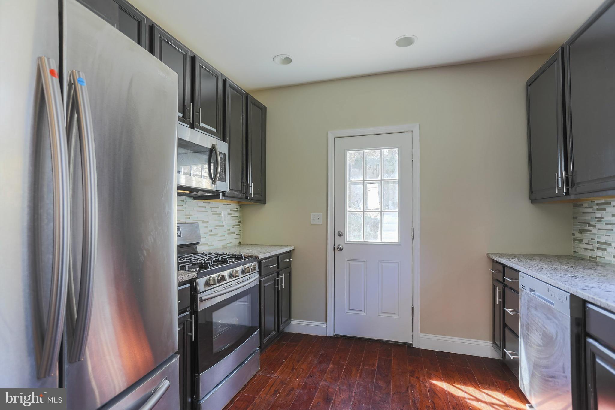 2304 Monticello Road Baltimore, MD 21216 - Photo 12 of 30 a kitchen with stainless steel appliances a stove a sink and a refrigerator