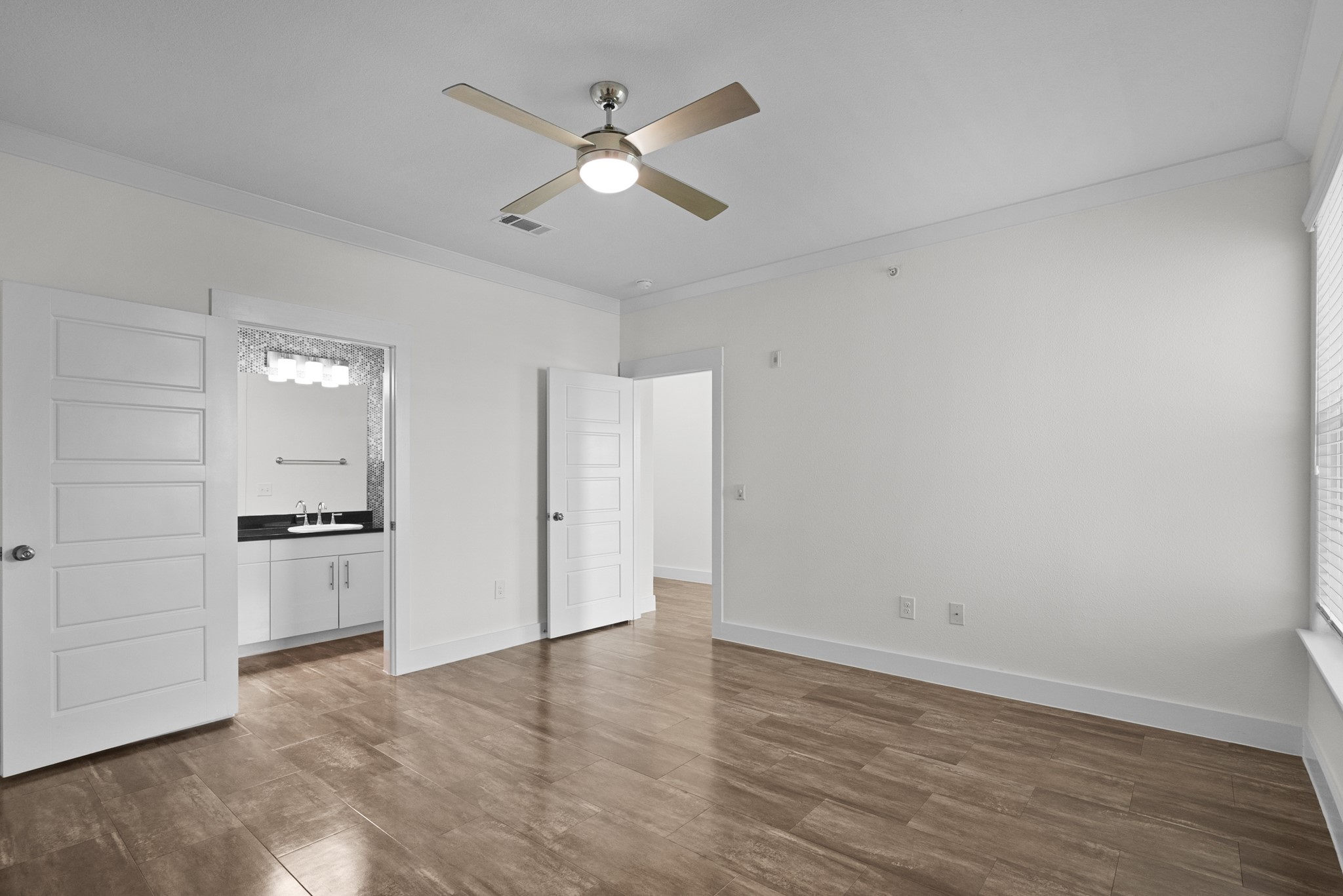 366 Fm 1488 Road, Unit 1042 Conroe, TX 77384 - Photo 16 of 38 an empty room with wooden floor ceiling fan and windows