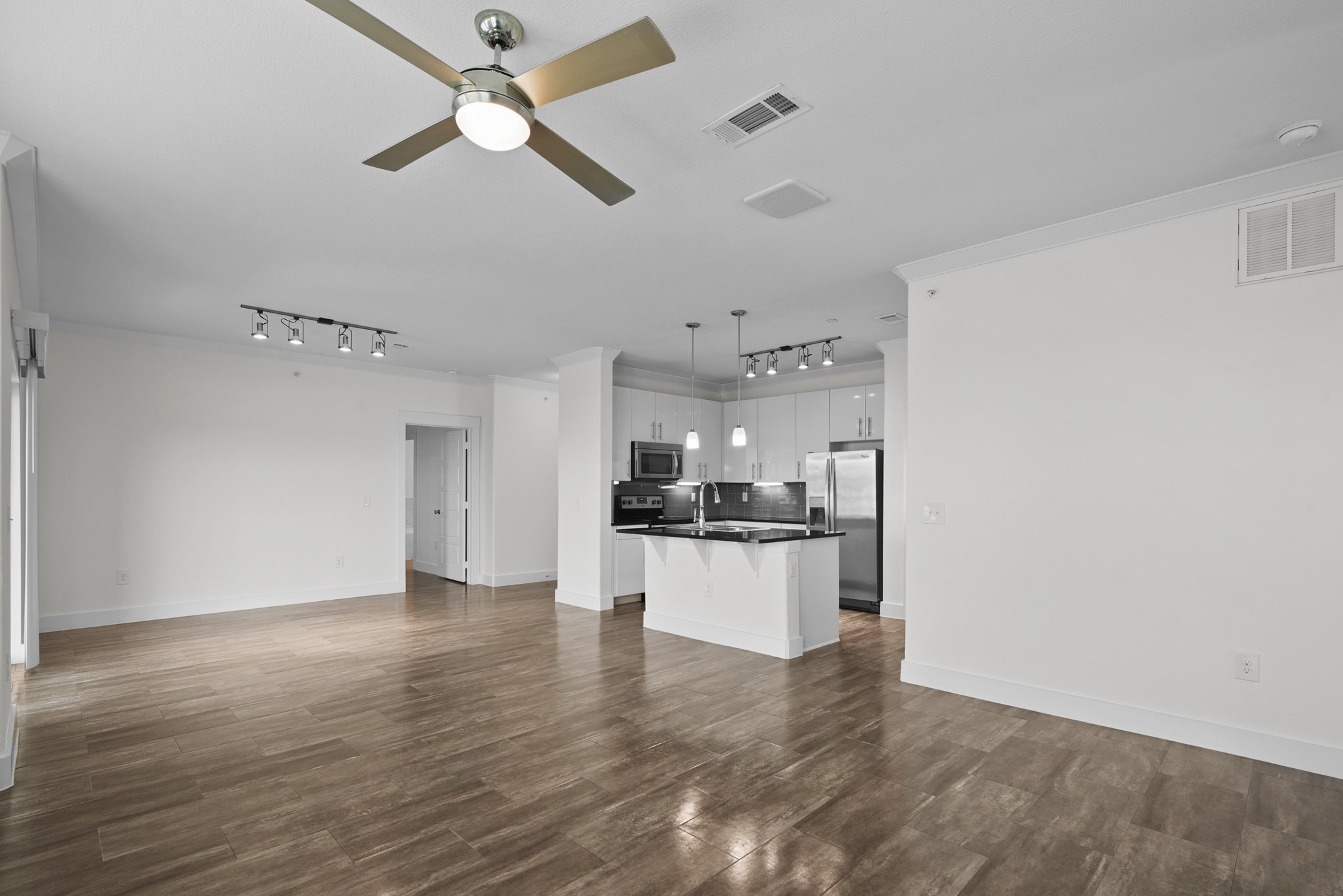 366 Fm 1488 Road, Unit 1042 Conroe, TX 77384 - Photo 7 of 38 a large kitchen with cabinets wooden floor and stainless steel appliances