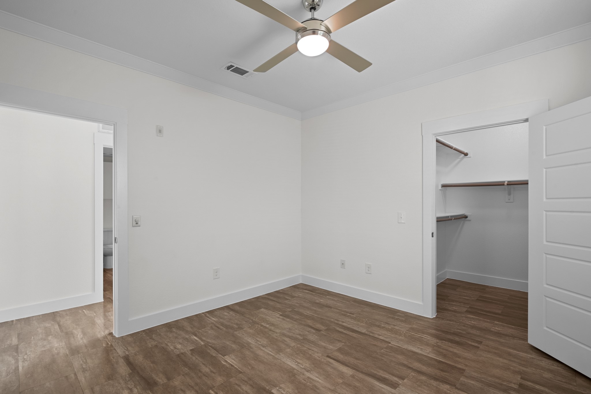 366 Fm 1488 Road, Unit 1042 Conroe, TX 77384 - Photo 10 of 38 an empty room with wooden floor and ceiling fan