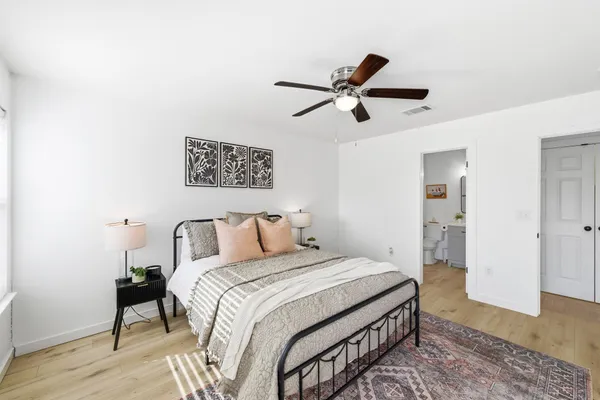 a bedroom with a large bed and a chandelier