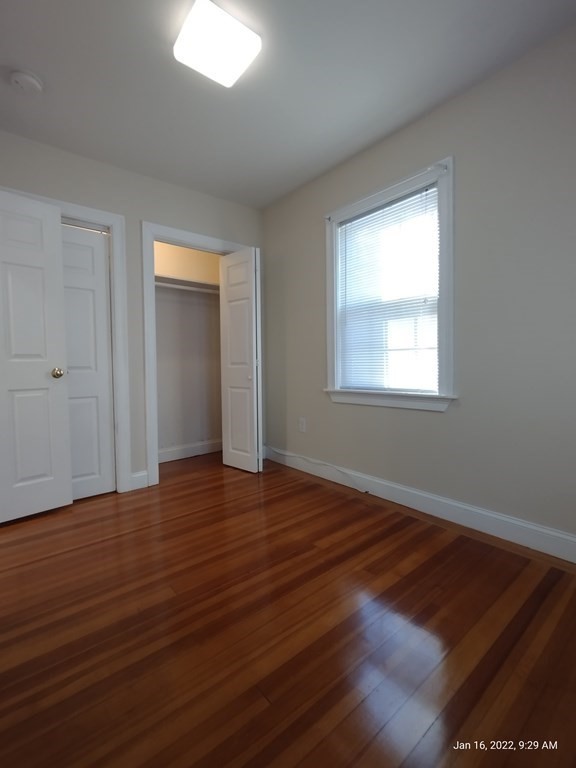 62 Washington Street, Unit 62 Wellesley, MA 02481 - Photo 13 of 18 an empty room with wooden floor and windows