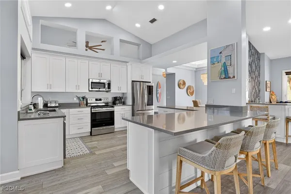 a large kitchen with stainless steel appliances granite countertop a stove and a sink