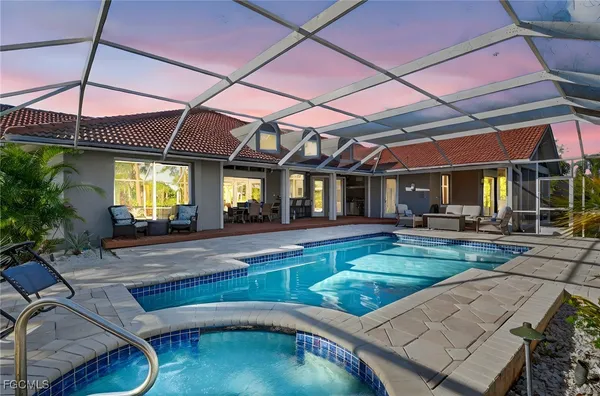 a view of a backyard with swimming pool table and chairs under an umbrella
