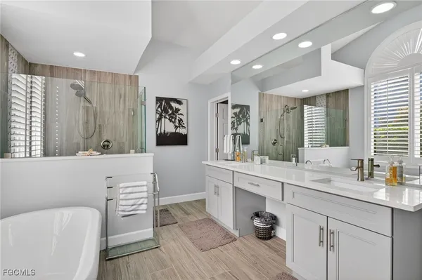 a bathroom with a double vanity sink a mirror and a bathtub