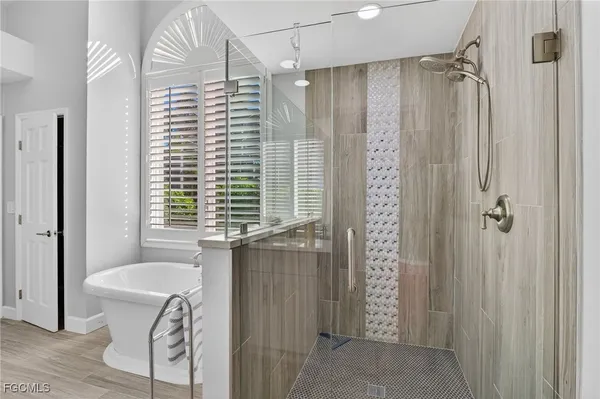a bathroom with a granite countertop sink a toilet a mirror and shower