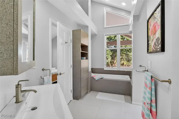 a bathroom with a tub sink and mirror