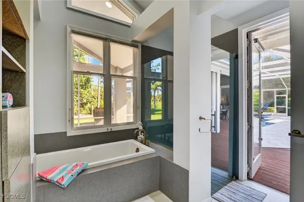 a bathroom with a tub a window and a shower