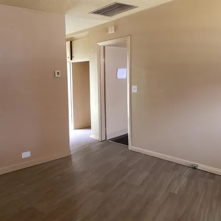 an empty room with wooden floor and closet