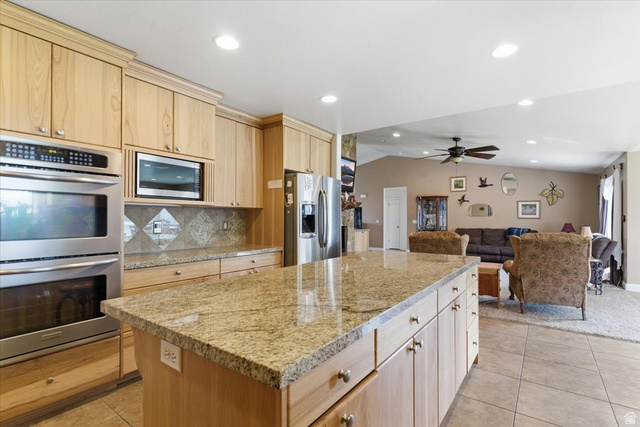 6237 West 4600th Street South Hooper, UT 84315 - Photo 48 of 48 Kitchen featuring light wood finish cabinets, stainless steel appliances, lofted ceiling, tasteful backsplash, and open floor plan