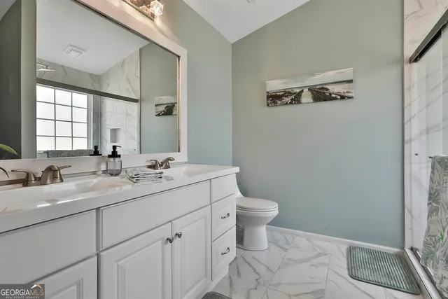 a bathroom with a double vanity sink toilet and a mirror
