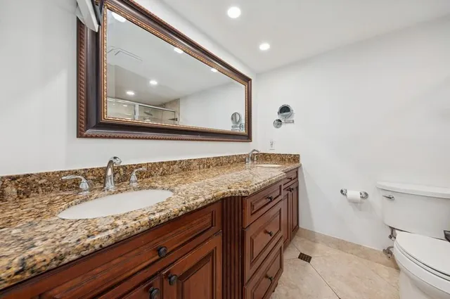 a bathroom with a granite countertop sink and mirror