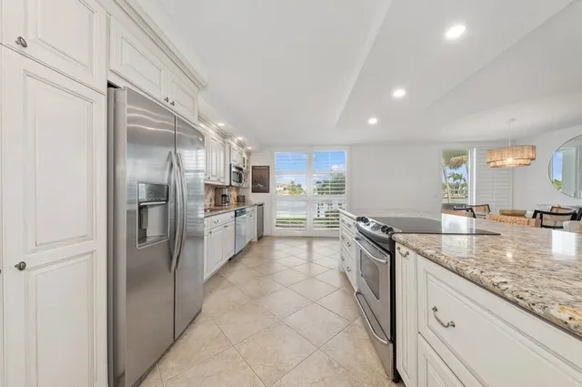 a kitchen with stainless steel appliances granite countertop a refrigerator and a sink