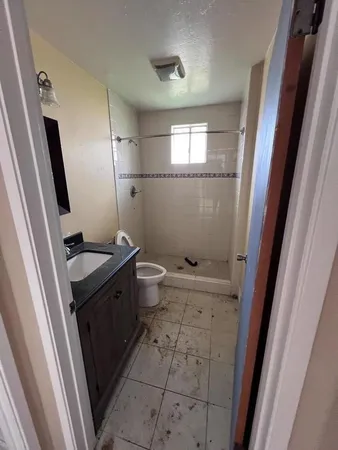 a bathroom with a granite countertop sink toilet and shower