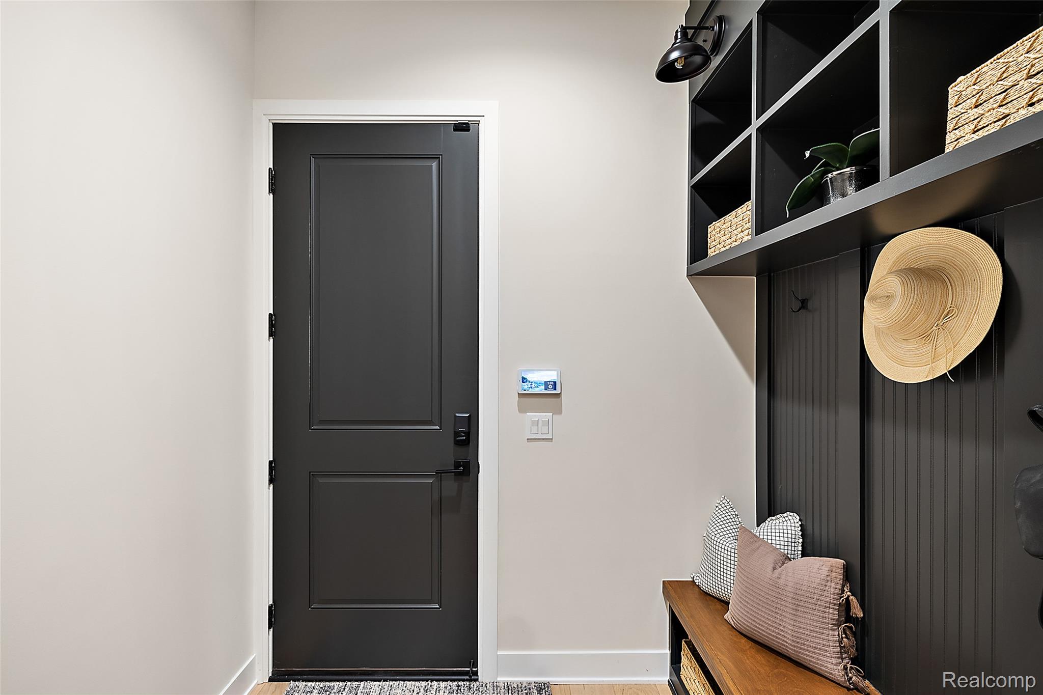 70413 Renata Court Romeo, MI 48065 - Photo 34 of 53 Sophisticated entryway featuring a black two-panel interior door, neutral wall finishes, and custom built-in shelving with open storage cubbies