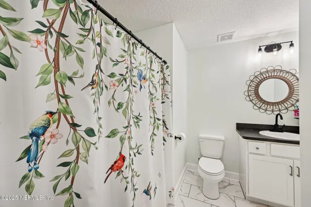 a bathroom with a toilet and a shower curtain