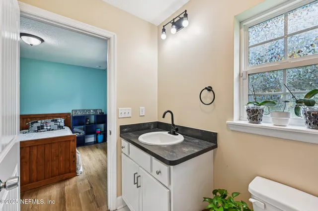 a bathroom with a granite countertop sink and a mirror