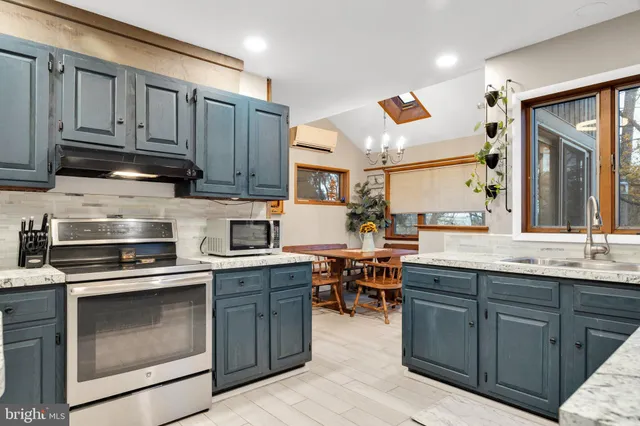 a kitchen with a stove and a wooden floor
