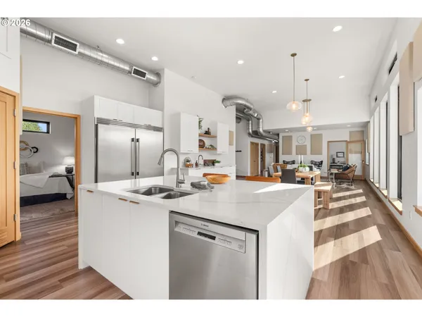a view of a kitchen with kitchen island a sink stainless steel appliances and cabinets