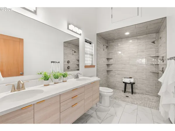 a bathroom with a double vanity sink toilet and a mirror