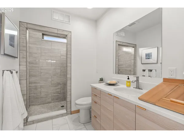 a bathroom with a granite countertop sink mirror toilet shower and bathtub