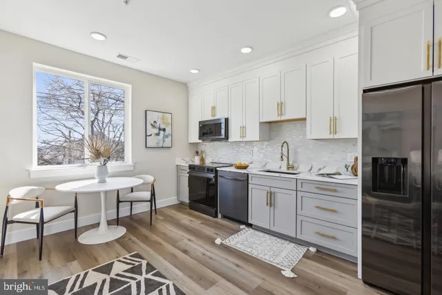 a kitchen with a refrigerator and a stove top oven