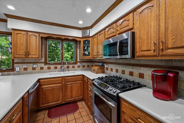 a kitchen with stainless steel appliances granite countertop cabinets and a window