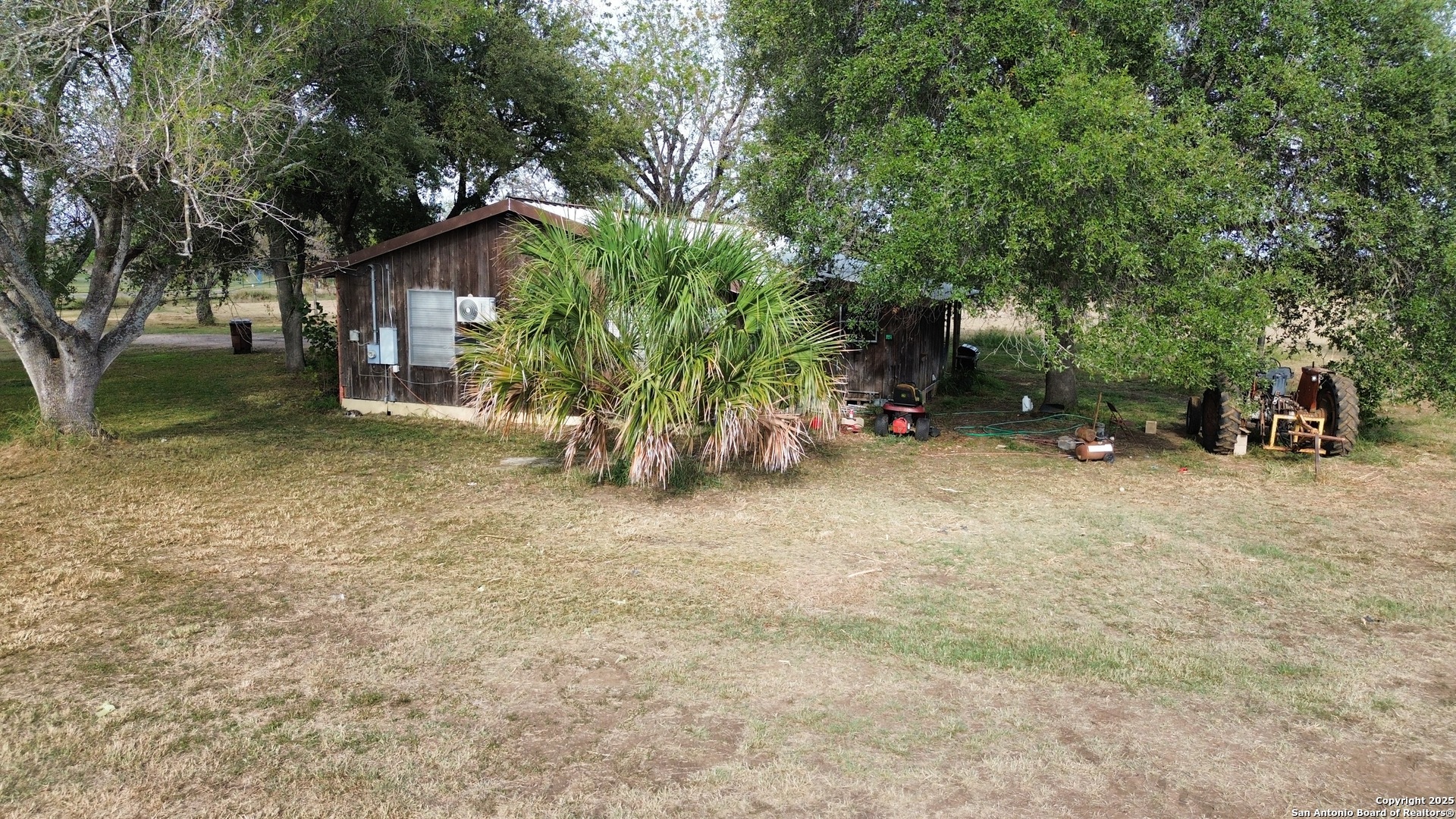 10620 Pearsall Road Atascosa, TX 78002 - Photo 5 of 8 a backyard of a house with barbeque oven table and chairs