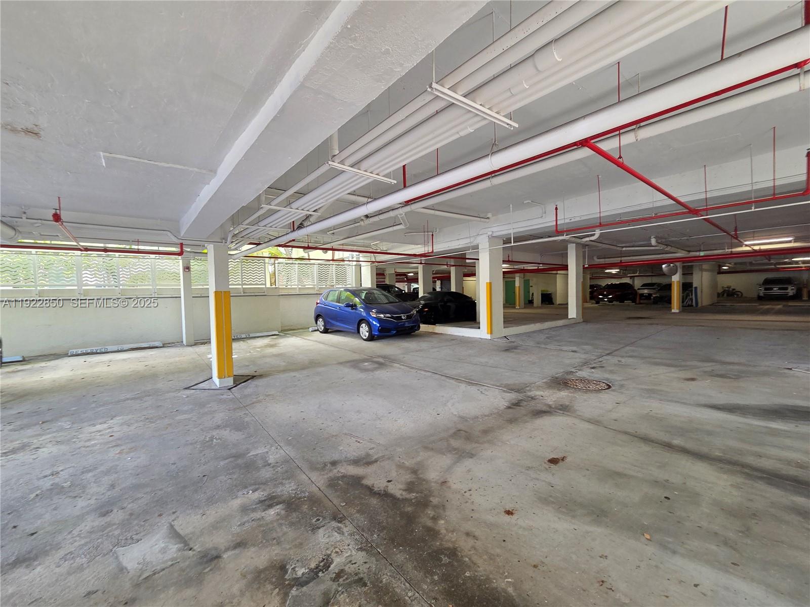 9172 Collins Avenue, Unit 403 Surfside, FL 33154 - Photo 17 of 24 a view of a big room with an empty space and a car parked