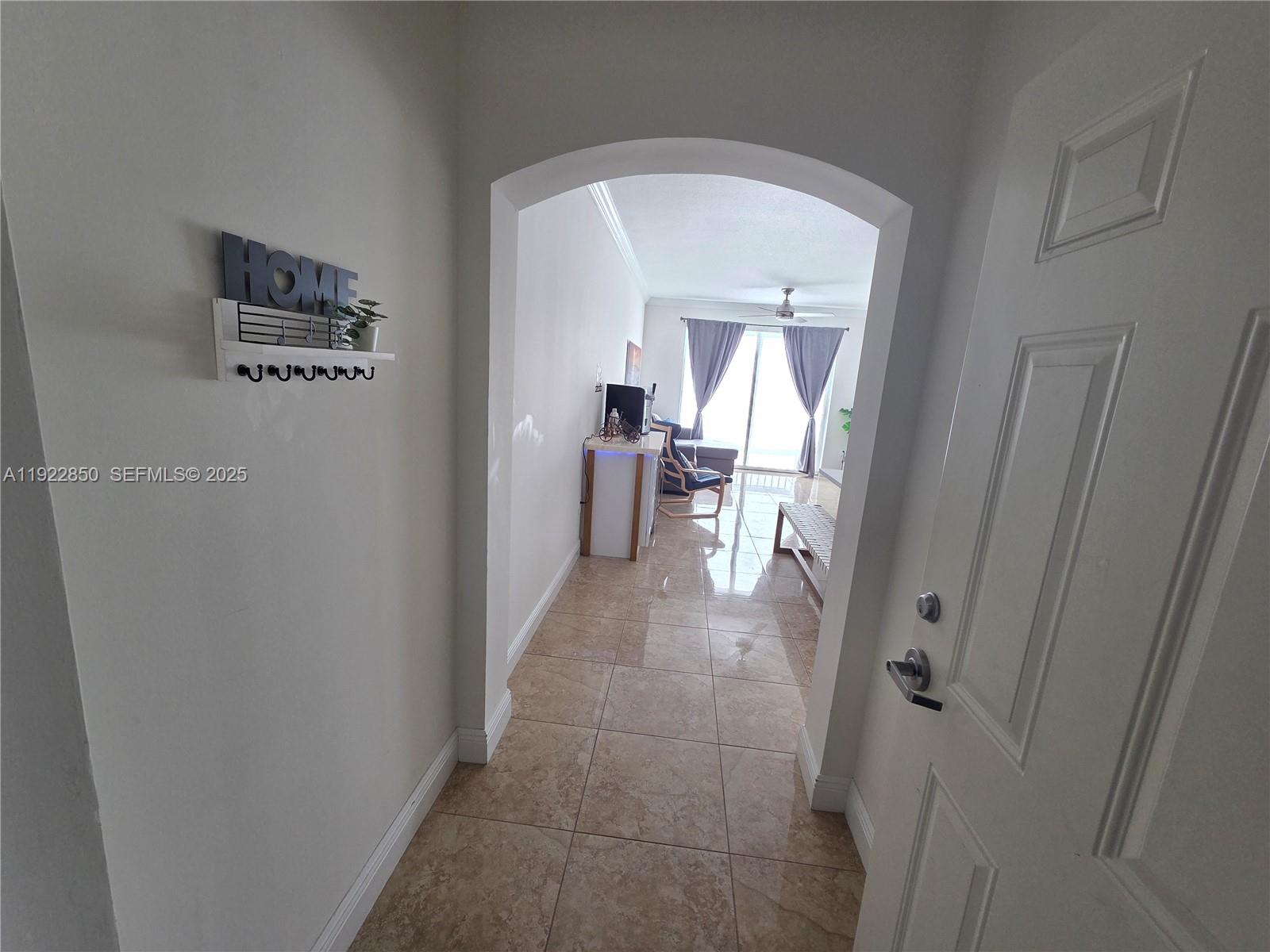 9172 Collins Avenue, Unit 403 Surfside, FL 33154 - Photo 2 of 24 a view of a hallway and a livingroom with a chair