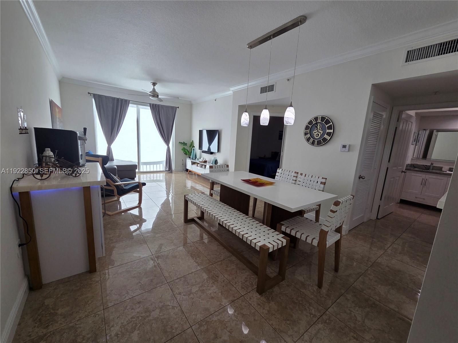 9172 Collins Avenue, Unit 403 Surfside, FL 33154 - Photo 5 of 24 a living room with furniture and a flat screen tv