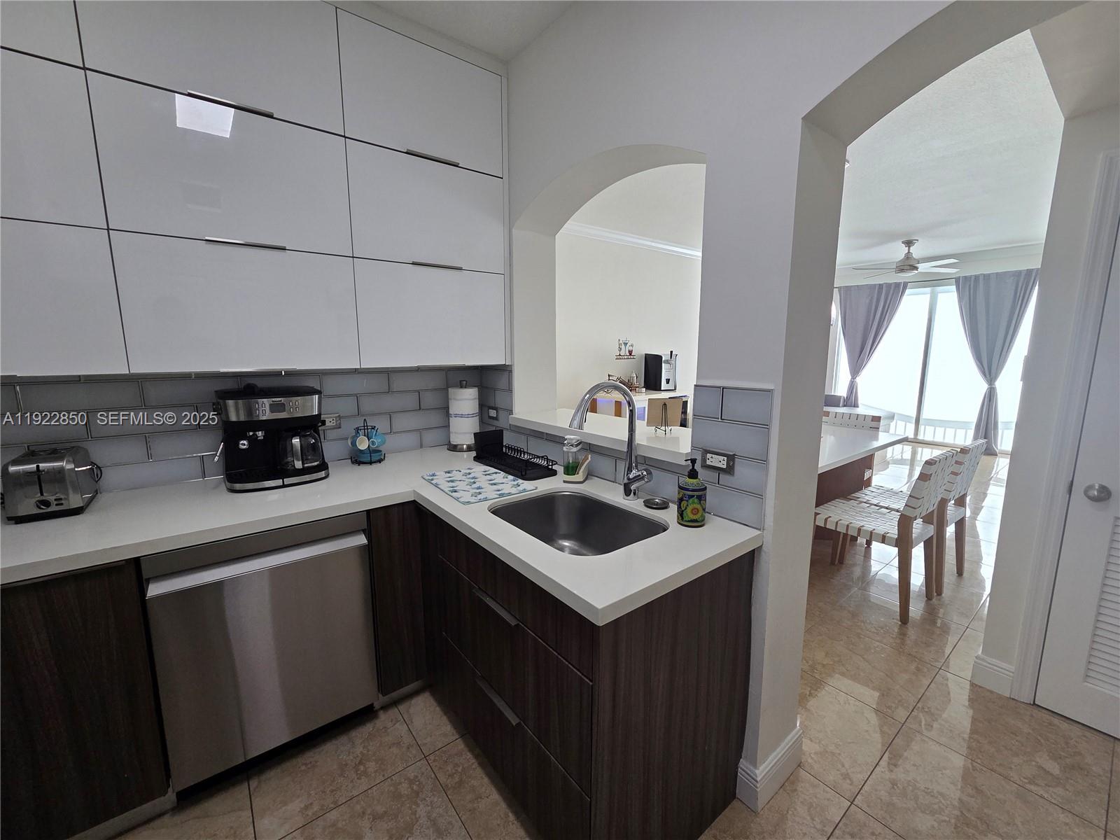9172 Collins Avenue, Unit 403 Surfside, FL 33154 - Photo 7 of 24 a kitchen with a sink stove and cabinets