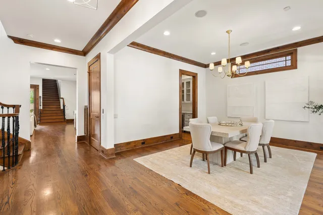 a dining room with wooden floor and a chandelier