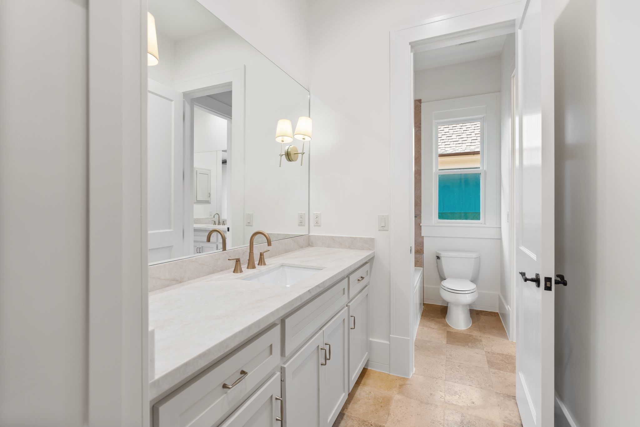 1815 Milford Street Houston, TX 77098 - Photo 23 of 33 SECONDARY BATHROOM III - Private vanity area features Taj Mahal quartz counters, brass fixtures, decorative sconces and stone flooring.