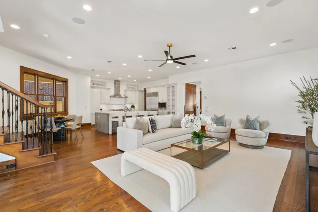 a living room with furniture kitchen view and a chandelier