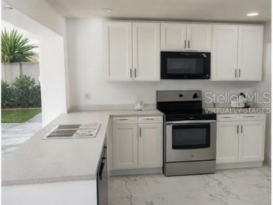 132 Miller Drive Winter Haven, FL 33884 - Photo 12 of 15 a kitchen with white cabinets and stainless steel appliances