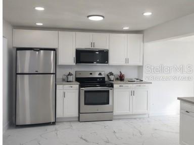 132 Miller Drive Winter Haven, FL 33884 - Photo 13 of 15 a kitchen with stainless steel appliances granite countertop a refrigerator stove a sink and a microwave