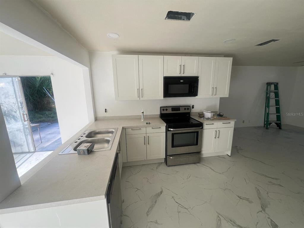 132 Miller Drive Winter Haven, FL 33884 - Photo 9 of 15 a kitchen with a stove and a microwave