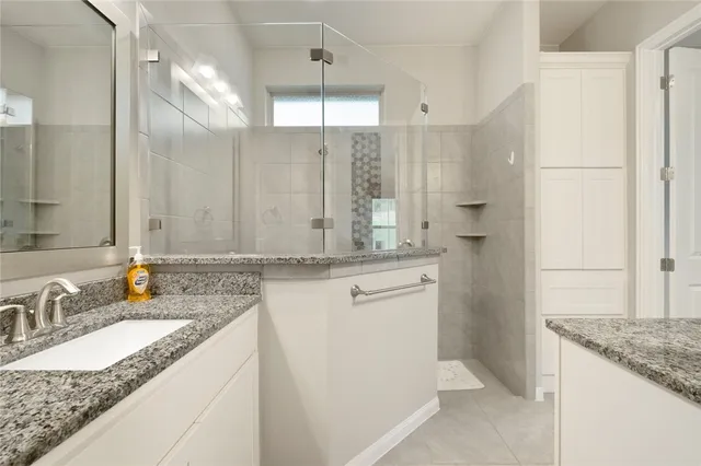 a bathroom with a granite countertop sink and a mirror