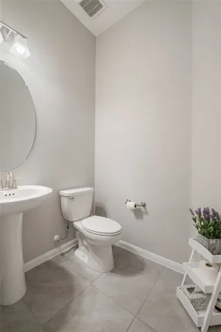 a white toilet sitting next to a bathroom sink and a mirror