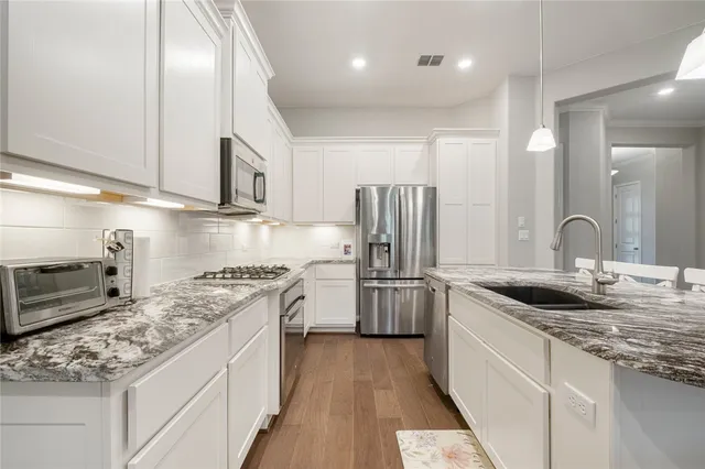 a kitchen with stainless steel appliances granite countertop a sink stove and refrigerator