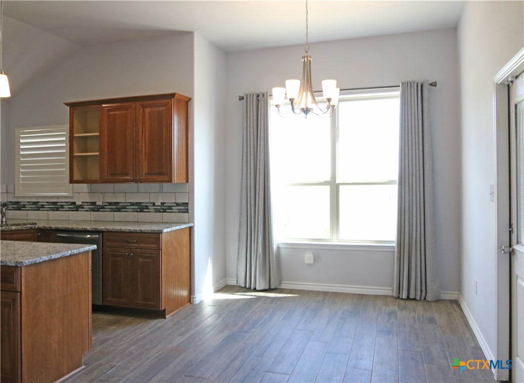2734 Rock Road Troy, TX 76579 - Photo 11 of 48 a kitchen with kitchen island granite countertop wooden floors and white appliances