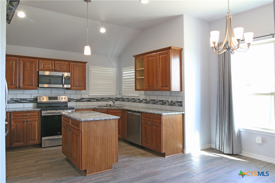 2734 Rock Road Troy, TX 76579 - Photo 5 of 48 a kitchen with stainless steel appliances granite countertop wooden cabinets a stove a sink and a refrigerator