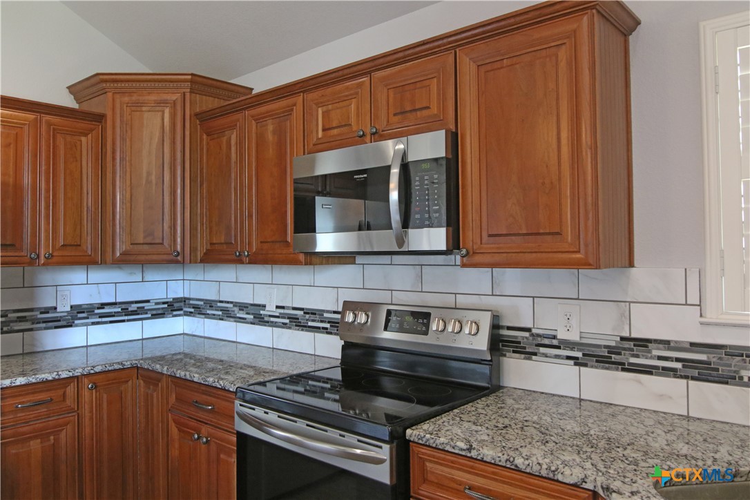 2734 Rock Road Troy, TX 76579 - Photo 8 of 48 a kitchen with wooden cabinets and a stove top oven