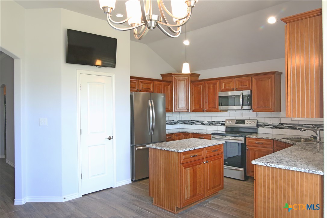 2734 Rock Road Troy, TX 76579 - Photo 9 of 48 a kitchen with stainless steel appliances granite countertop a refrigerator a stove a sink dishwasher and wooden cabinets with wooden floor