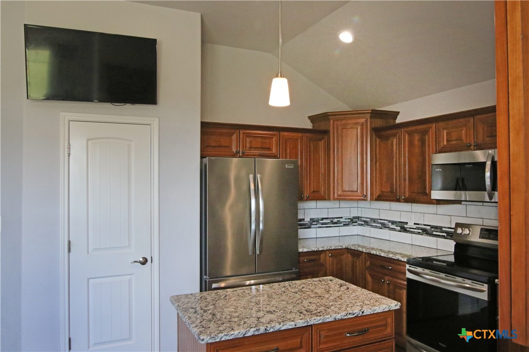 2734 Rock Road Troy, TX 76579 - Photo 10 of 48 a kitchen with stainless steel appliances granite countertop a stove microwave and refrigerator